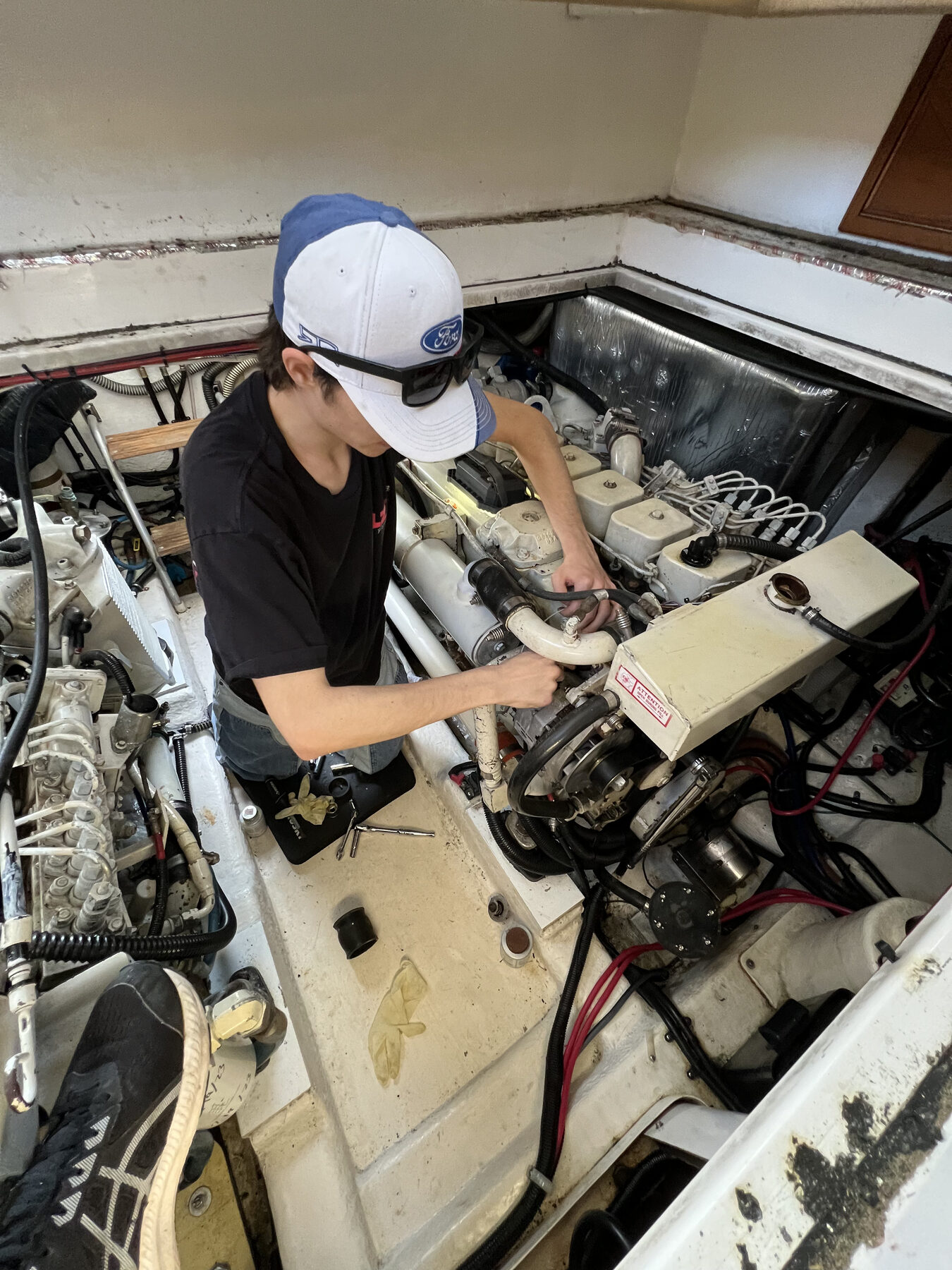 Marine technician servicing a yacht engine in the engine room