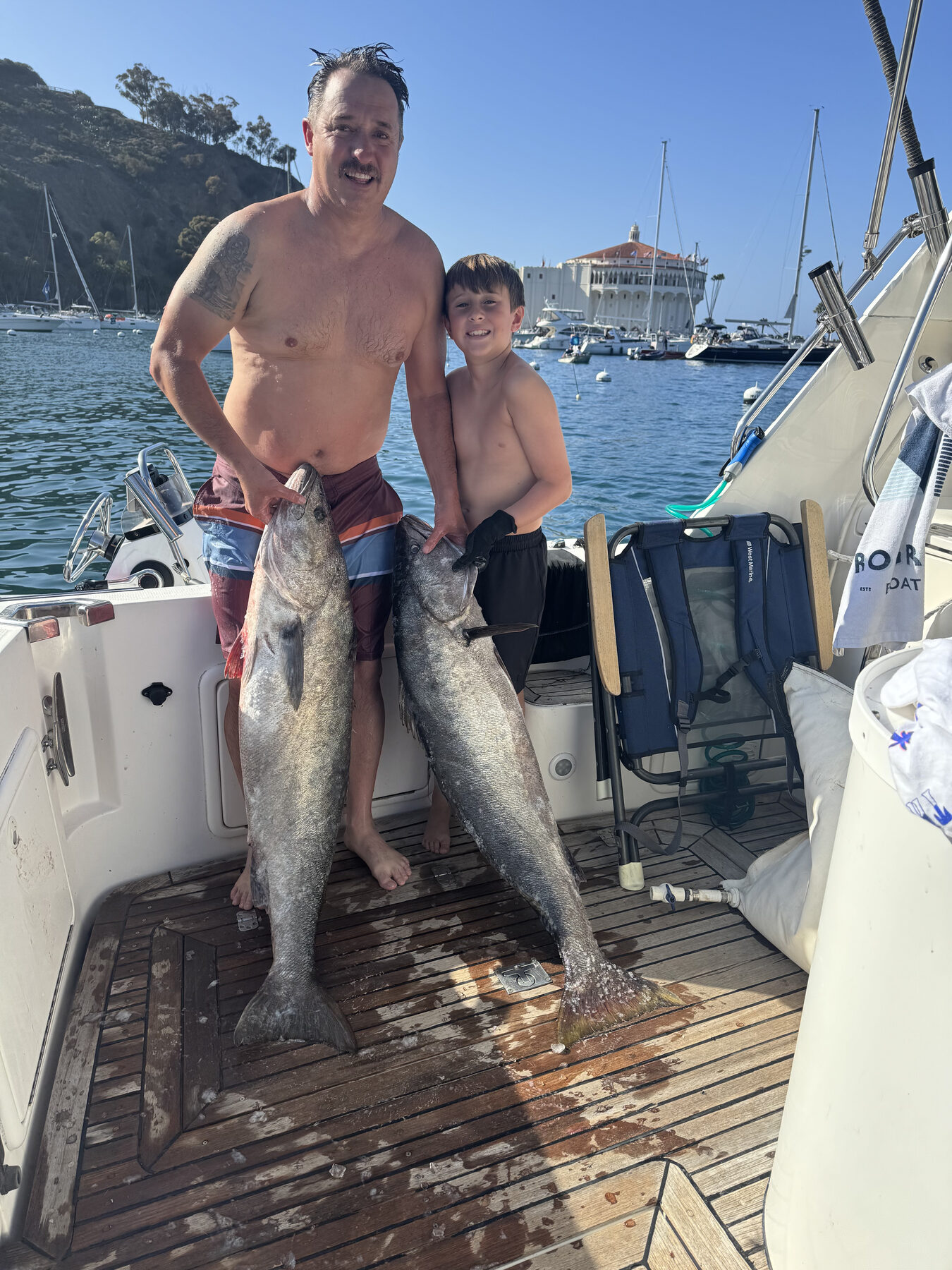 Captain with a young angler holding two large fish at Catalina Island